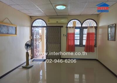 Living room with front door and windows