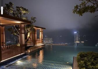 Night view of an outdoor pool overlooking a city skyline