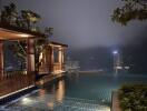 Night view of an outdoor pool overlooking a city skyline