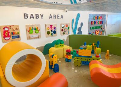 Colorful baby play area with various toys and interactive wall games