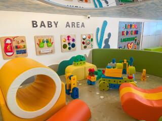 Colorful baby play area with various toys and interactive wall games