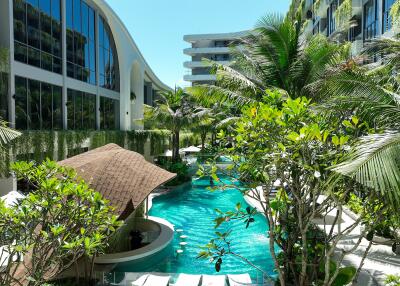 Luxurious pool area surrounded by lush greenery and modern buildings