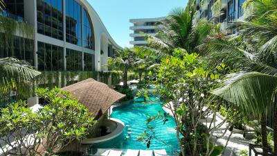 Luxurious pool area surrounded by lush greenery and modern buildings