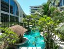 Luxurious pool area surrounded by lush greenery and modern buildings