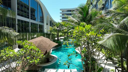 Luxurious pool area surrounded by lush greenery and modern buildings