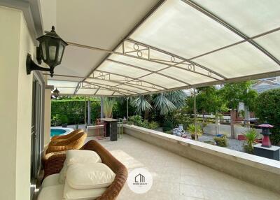 Covered patio area with seating and garden view