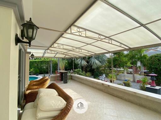 Covered patio area with seating and garden view