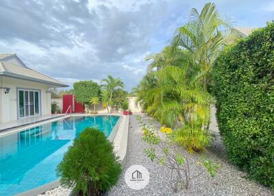 Outdoor area with swimming pool and lush greenery