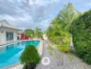 Outdoor area with swimming pool and lush greenery