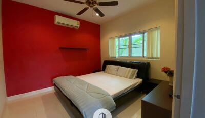 Spacious bedroom with a large window, air conditioner, and ceiling fan