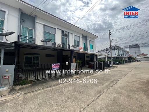 Front view of modern townhouse with driveway and street