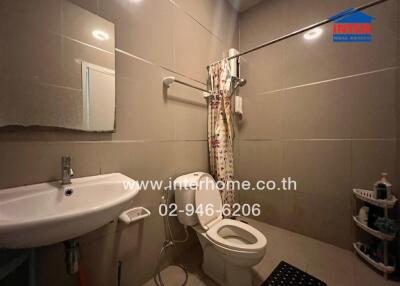 Modern bathroom with sanitary amenities and shower curtain