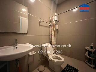 Modern bathroom with sanitary amenities and shower curtain