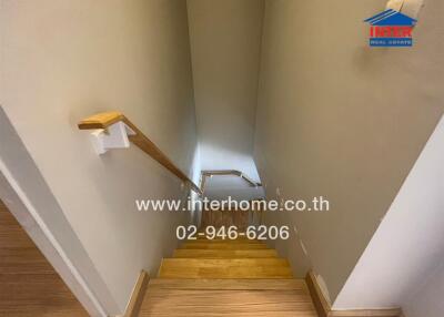 Indoor wooden staircase with handrail