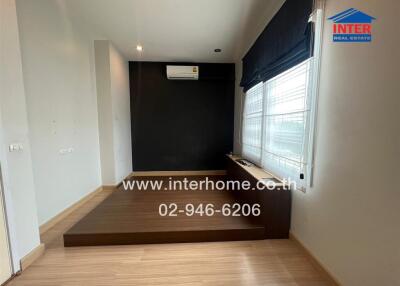 Modern bedroom with wooden flooring and large window