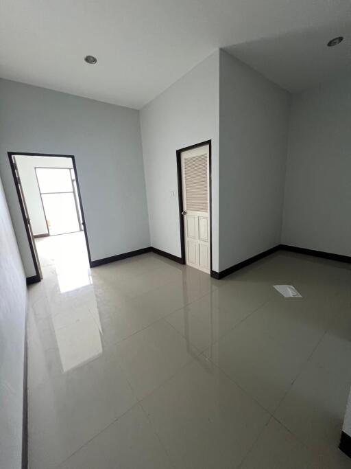 Bedroom with tiled floor and door leading to another room