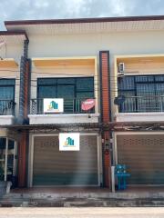 Two-story commercial building with signage and a balcony