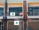 Two-story commercial building with signage and a balcony