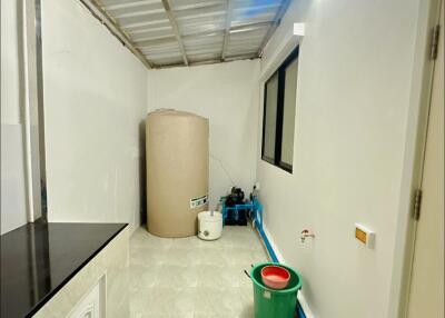 Utility area with water tank and plumbing