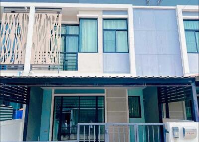 Front view of a modern two-story house with a gated entrance