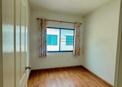 Empty bedroom with wooden floor and a window