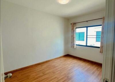 Empty bedroom with wooden floor and a window