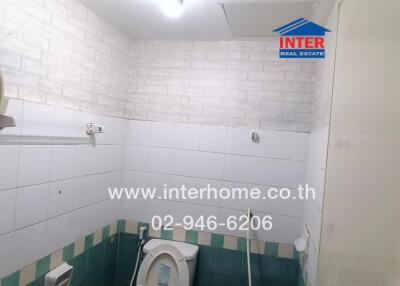 Bathroom with wall-mounted mirror, toilet, and tiled walls