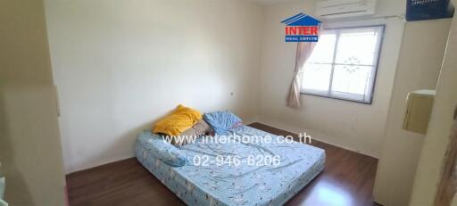 Simple bedroom with a mattress, window, and air conditioning unit