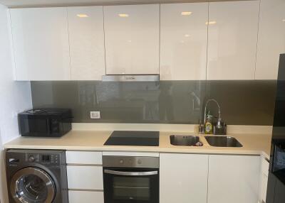 Modern kitchen with white cabinetry, built-in appliances, and backsplash