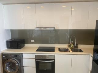 Modern kitchen with white cabinetry, built-in appliances, and backsplash