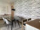 Contemporary-styled dining room with brick accent wall and glass table