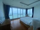 Spacious bedroom with large windows offering ocean view