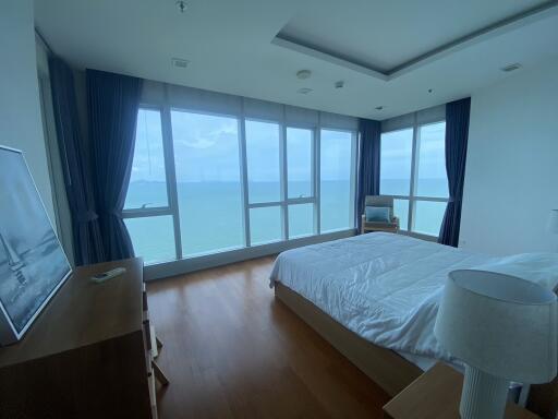 Spacious bedroom with large windows offering ocean view