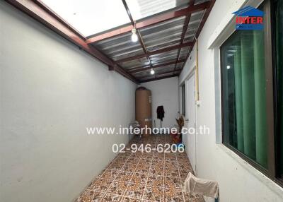 Long narrow utility area with tiled floor and exposed ceiling