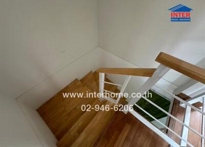 Wooden staircase with handrail and white wall