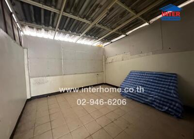 Empty room with tiled floor and corrugated metal ceiling