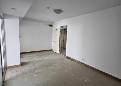 Empty main living space with tiled floor and a door