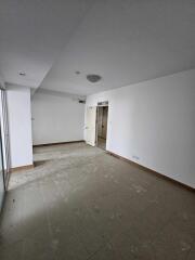 Empty main living space with tiled floor and a door