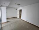 Empty main living space with tiled floor and a door