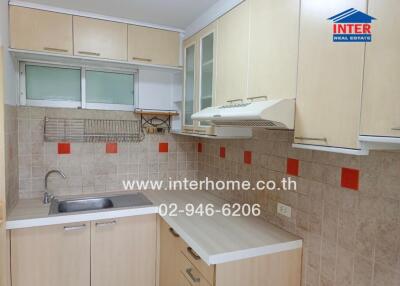 Modern kitchen with light wood cabinets and accented backsplash