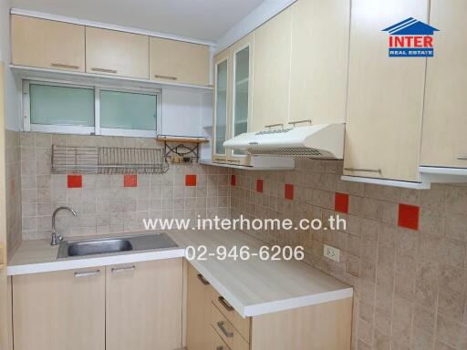 Modern kitchen with light wood cabinets and accented backsplash