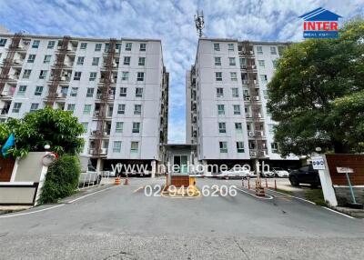 Front view of multi-story apartment building with parking area