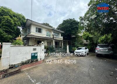 Front view of a residential house with driveway and cars