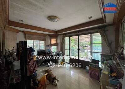 Living room with large windows, ceiling lights, and various furniture and items