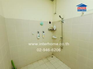 Simple bathroom with shower, tiled walls, and floor.