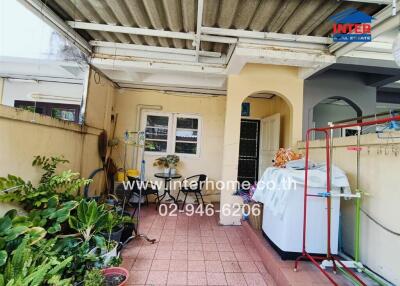 Covered patio area with plants and laundry equipment