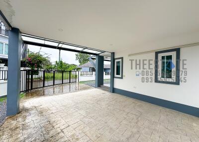 Covered garage area with view of driveway and gate