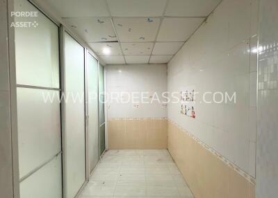 Empty room with tiled floors and partial wall tiling