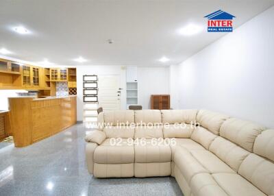 Spacious living room with modern furnishings and adjacent kitchen area