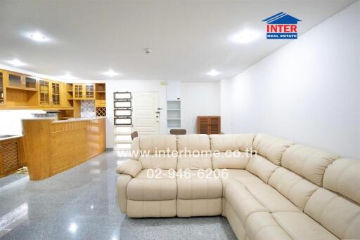 Spacious living room with modern furnishings and adjacent kitchen area